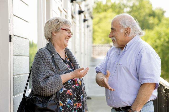 foto van twee buurtbewoners (een man en een vrouw) in gesprek