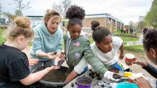 Foto van kinderwerker en kinderen maken zaadbommetjes