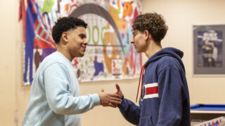Jongeren geven high five in jongerencentrum de boog