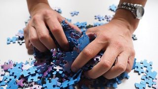 foto van handen met stukje van een legpuzzel