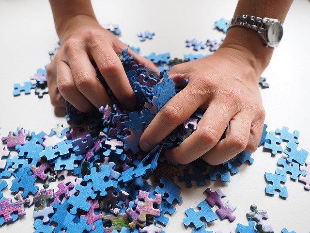 foto van handen met stukje van een legpuzzel