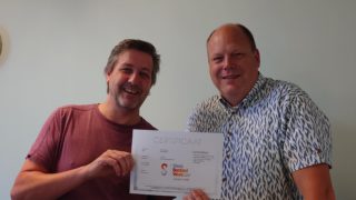 foto van twee medewerkers met het kwaliteitscertificaat