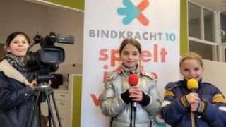 drie kinderen met filmcamera en microfoon in hun handen