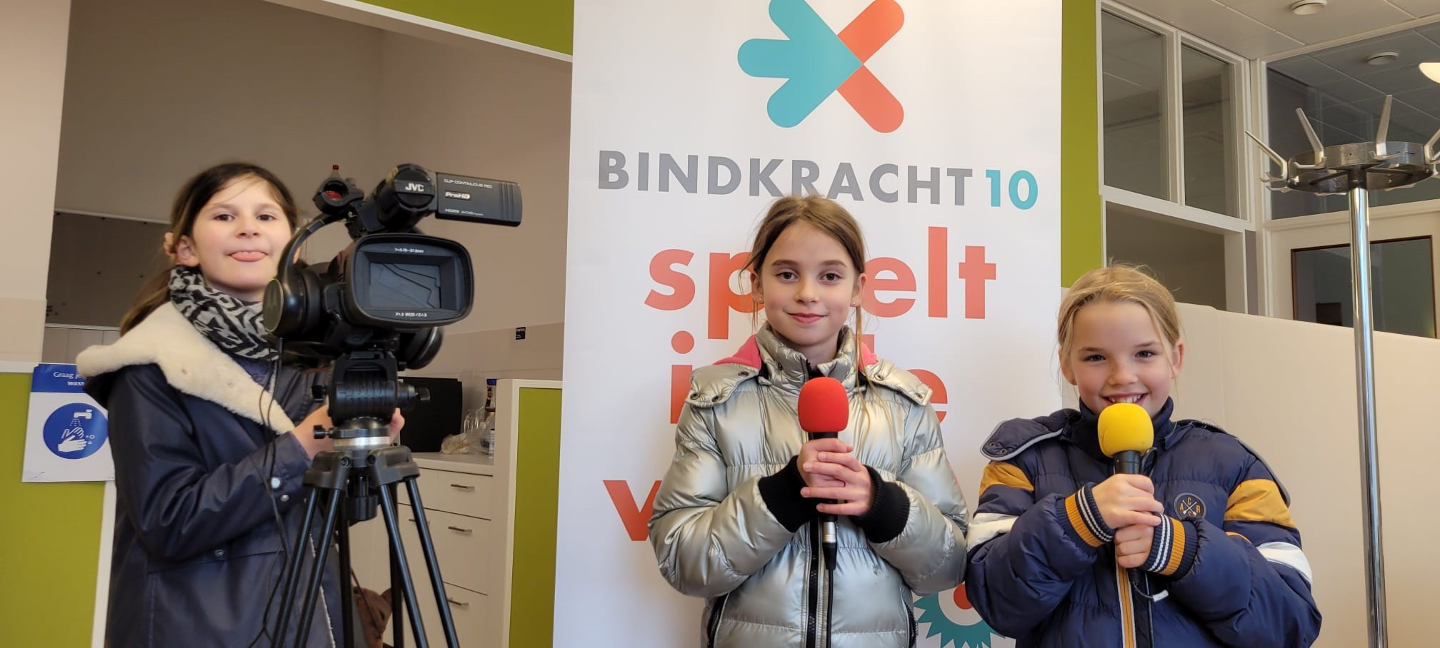 drie kinderen met filmcamera en microfoon in hun handen