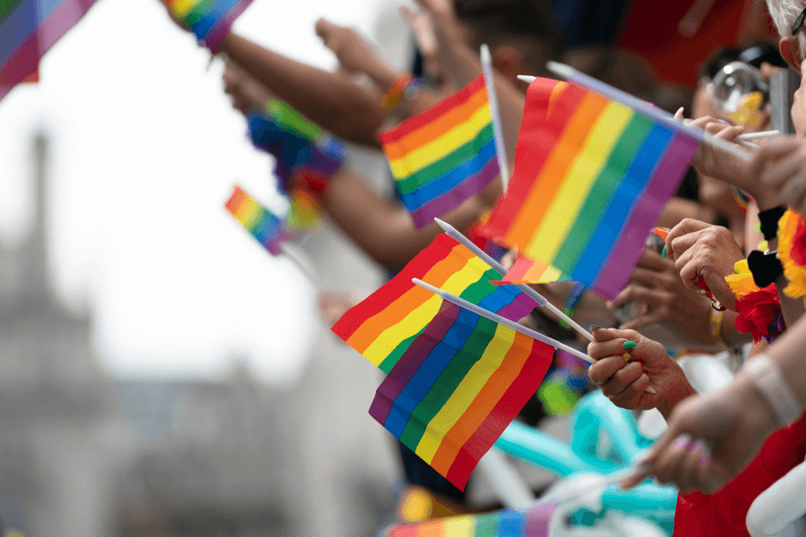 handen zwaaien met regenboogvlaggetjes