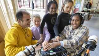 Foto kinderwerker met vier kinderen zijn podcast aan het maken