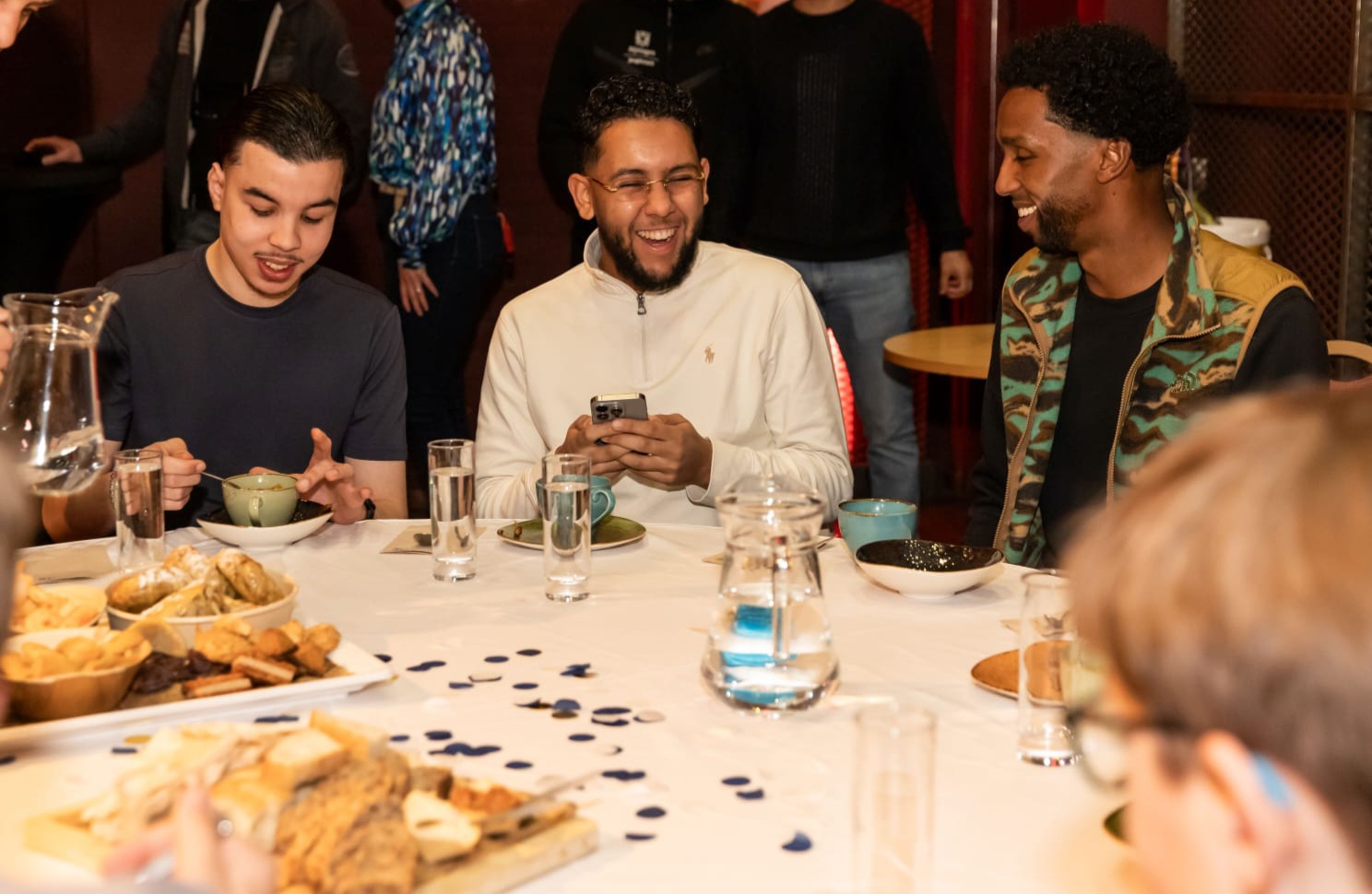 Jongerenwerker Mohamed Ired met twee andere jongeren aan tafel tijdens iftar