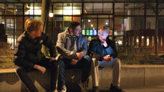 een foto van een jongerenwerker in de wijk met jongeren