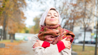 Jonge vrouw geeft zichzelf een knuffel
