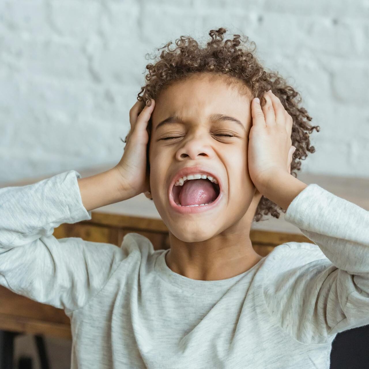 kind met handen over oren