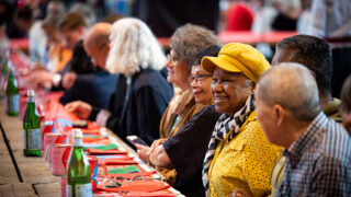 mensen aan een lange tafel bij vrijheidssoep