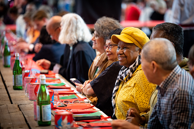 mensen aan een lange tafel bij vrijheidssoep