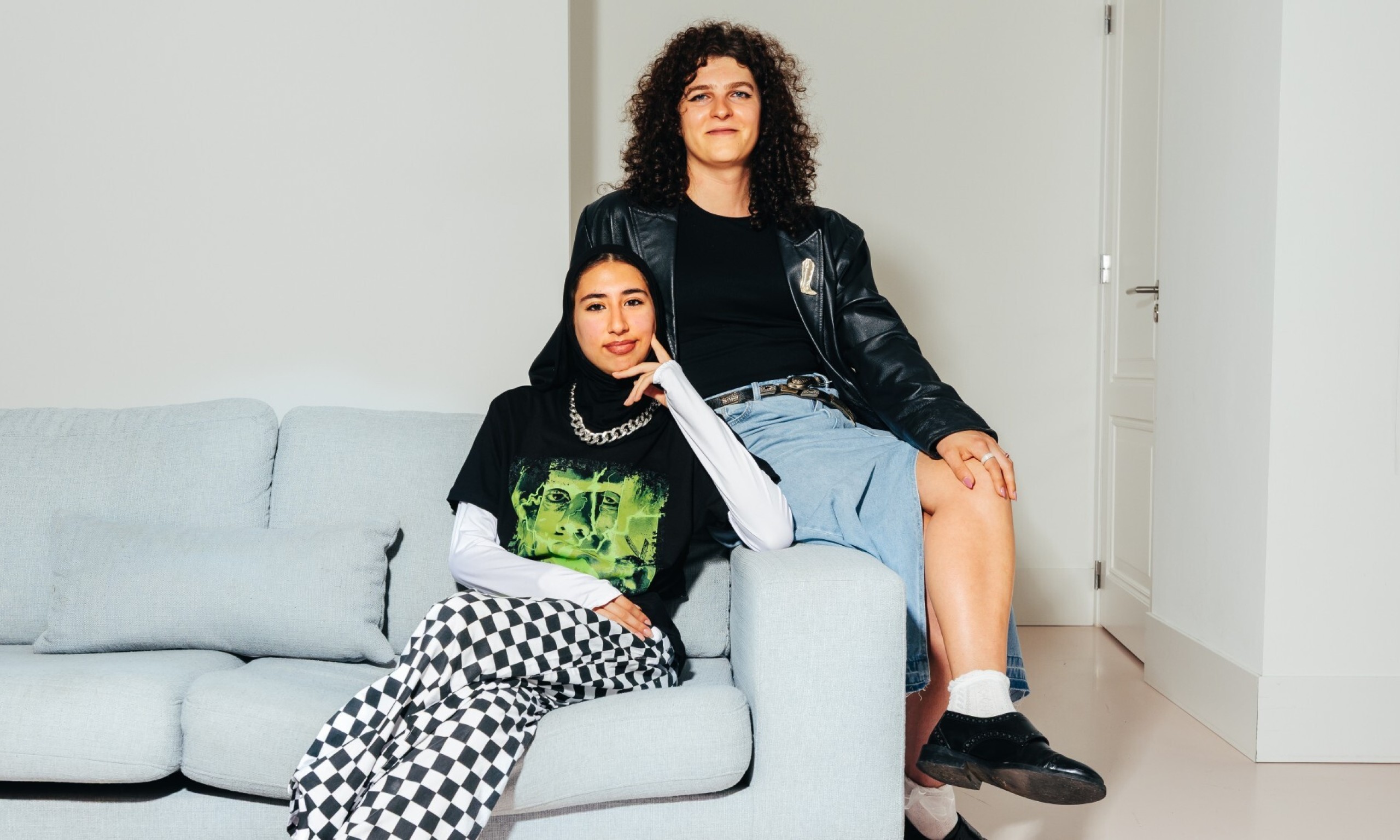 Twee jonge vrouwen op een bank kijken de kijker aan