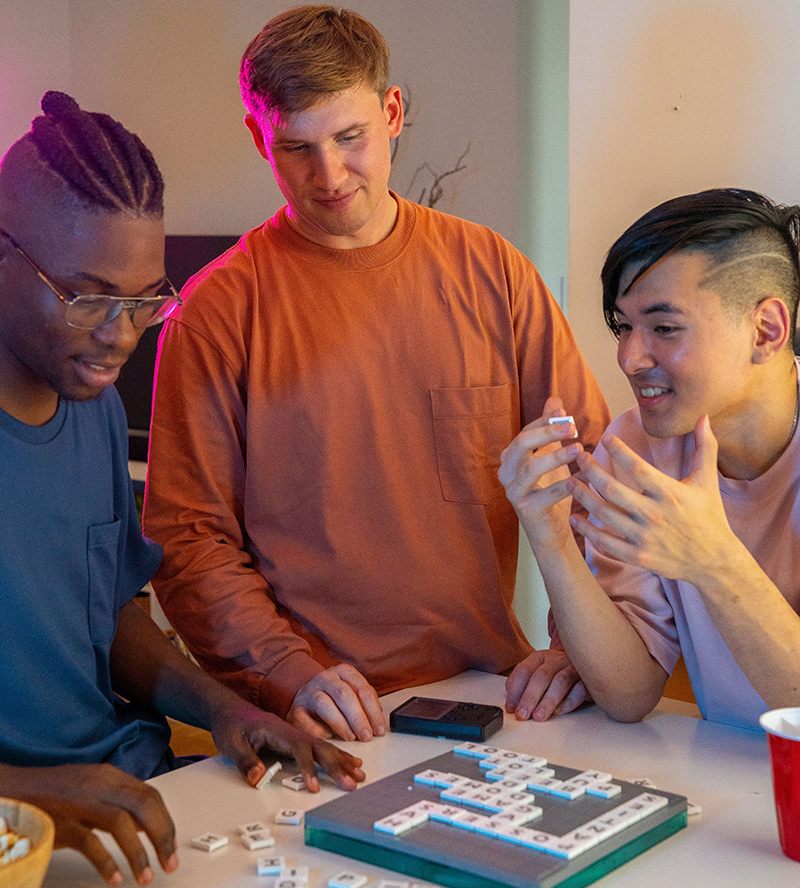 drie jonge mannen die scrabble spelen